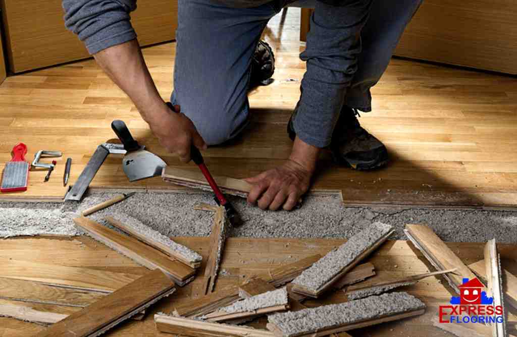 How do you flatten a buckled hardwood floor?